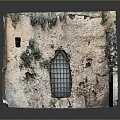 Rustic Casement Window With Iron Grille On Old Stone Wall And Green Plants