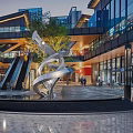 Modern Urban Commercial Street With Glass Facades Sculpture Escalators And Evening Pedestrians