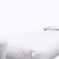 Dark Brown Leather Ottoman with Gray Blanket and Brass Vase in Modern Sleek Design