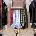 Stylish Clothes Hangers With Hanging Clothes Bags And Hats Against Geometric Patterned Wall