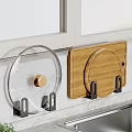 Transparent Pot Lid And Wooden Cutting Board Hanging On Black Hooks For Kitchen Wall