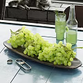 Ceramic Dish with Green Grapes on Blue Outdoor Table and Glass Cups with Green Drink