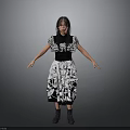 Woman In Black And White Patterned Dress Standing With Arms Outstretched Against Gray Background
