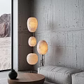 Abstract Floor Lamp With Three White Shades Black Metal Stand Gray Concrete Wall Mountain View
