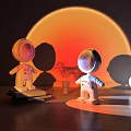 White Spherical Table Lamp With Astronaut Figurines Orange Circular Background And Small Potted Plant