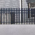 Modern Black Slatted Entrance Gate With Gray Pillars And Mountain View Greenery