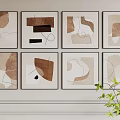 Eight Abstract Paintings on Wall with Geometric Shapes Lines Neutral Tones Black Frames Green Plant
