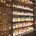 Liquor Cabinet With Multiple Shelves Filled With Various Wine And Whiskey Bottles