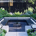 Modern Landscape Seating In Outdoor Garden With Lush Green Plants And Central Fire Pit