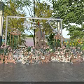 Elegant Outdoor Event Entrance With White Frame Floral Decorations And Green Trees