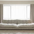 Neutral Toned Large Sofa in Living Room With Floor To Ceiling Curtains And Soft Rug