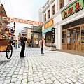 Traditional Chinese Commercial Street With Cobblestone Pavement Shop Signs And Pedestrians