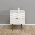 White Nightstand with Two Textured Drawers and Gold Legs Against Gray Wall on Wooden Floor