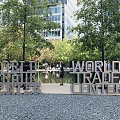 World Trade Center Sculpture in Urban Park with Trees and Visitors Nearby