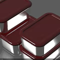 Three Household Metal Containers with Red Lids on Smooth Shiny Surface