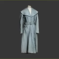 Man In Light Blue Long Coat With Collar And Belt Standing Against Gray Background