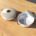 Stainless Steel Cooking Pots With Open And Closed Lids On Wooden Tabletop