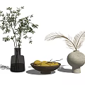 Glass Vase With Green Branches And White Vase With Feathery Plants Alongside Wooden Bowl Of Lemons