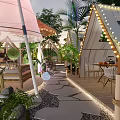 Outdoor Restaurant With Thatch Roof Tent Structure String Lights And Green Plants