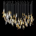 Gold and Silver Feather Shaped Chandelier Hanging Illuminated in Black Background