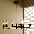 Modern Chandelier With Glass Shades Lit Bulbs And Warm Light By Window Blinds