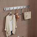Wall Mounted Hook With Hanging Coat Stuffed Toy Spoon And Handbag On Brown Striped Wall