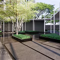 Modern Entrance Gate With Stone Columns Glass Canopy And High Rise Building Facade