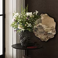 Black Textured Vase With White Purple Flowers On Dark Table Near Round Decorative Mirror