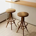 Two Wooden Bar Stools With Round Seats In Light Interior By Wooden Countertop