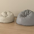 Two Beige Checkered and Gray Bean Bag Chairs on Wooden Floor with Light Wall
