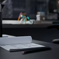 Robot Figure On Office Desk With Desk Lamp Green Mouse Pad And City Skyline View