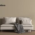 Poliform White Sofa Bed With Pillows Checked Blanket And Potted Plant On Wooden Floor