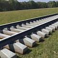 Road Facilities Railroad Tracks With Concrete Sleepers Lying In Green Grassland Field