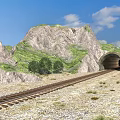 Railway Track Leading To Mountain Tunnel With Green Hills And Blue Sky