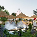 Garden Landscape with Thatched Umbrellas Lounge Chairs Steam Pool Rocks and Green Plants