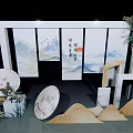 Chinese Style Decorative Display Featuring Screen with Landscape Art Fans Floral Arrangements and Mountain Decor
