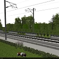Scenic Railway Tracks With Overhead Wire Poles Green Trees Grass And Hedge