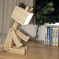 Unique Wooden Table Lamp with Creative Design on Wooden Desk Beside Books and Green Plant
