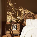 Wooden Nightstand Beside Bed With Vintage Lamp Flower Vase And Photo In Sunlight Shadows
