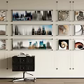Multiple Abstract Paintings Hung on Wall with Spiral and Cityscape Patterns and Black Cabinet Below