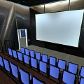 Contemporary Cinema Interior With Large Projection Screen Blue Seats And Stadium Seating