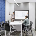 Modern Conference Room with Blue Herringbone Wall Projection Screen Standing Presenter and Seated Person
