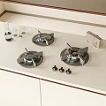White Kitchen Countertop With Three Gas Stove Burners Knobs Water Bottle And Light Cabinets