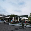 Modern Urban Commercial Street Landscape Design With Outdoor Umbrellas Pedestrians And Greenery