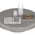Light Colored Round Table With Open Book And Golden Cover Book Transparent Bottle Small Cup