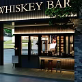 Whiskey Bar Exterior At Night With Bar Counter Stools And Lighting