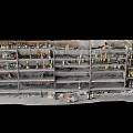 Burned Storage Shelves With Multiple Layers Of Charred Items And Scattered Debris