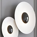 Modern Circular Wall Lamps With White Shade And Dark Center Mounted On Gray Wall