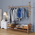 Golden Metal Clothing Rack With Hanging Shirts Jeans Folded Clothes And Shoes In Bedroom