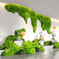 Indoor Landscape Featuring Green Moss Waterfall Wall Silver Sculptures Yellow Spheres Black Stones White Pedestals